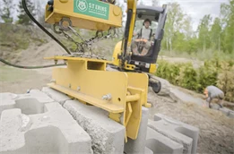 Montering av Verticamur med hjälp av en liten grävmaskin och ett hydrauliskt lyftverktyg för Verticamur.